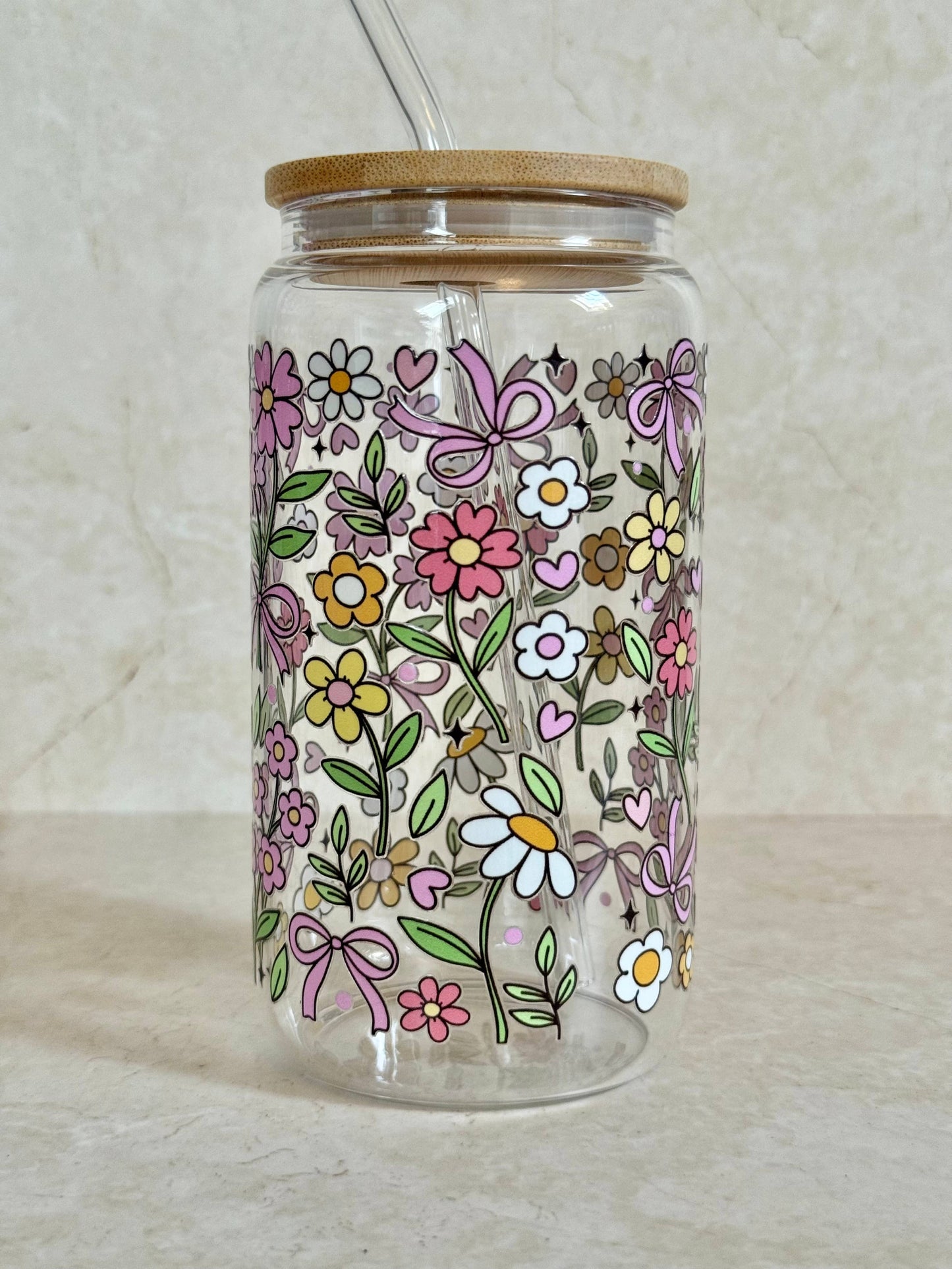 Glasbecher mit Blumenumriss, Bambusdeckel und Glasstrohhalm